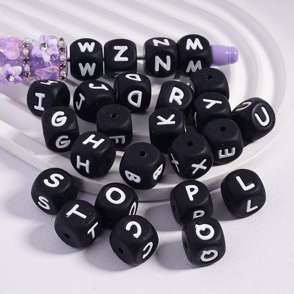 Black letter beads with white letters on a white background