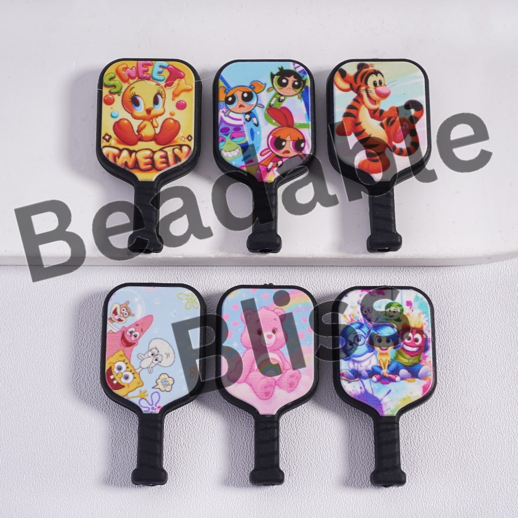 Set of colorful cartoon-themed paddle designs on a white background with 'beadablebliss' branding.