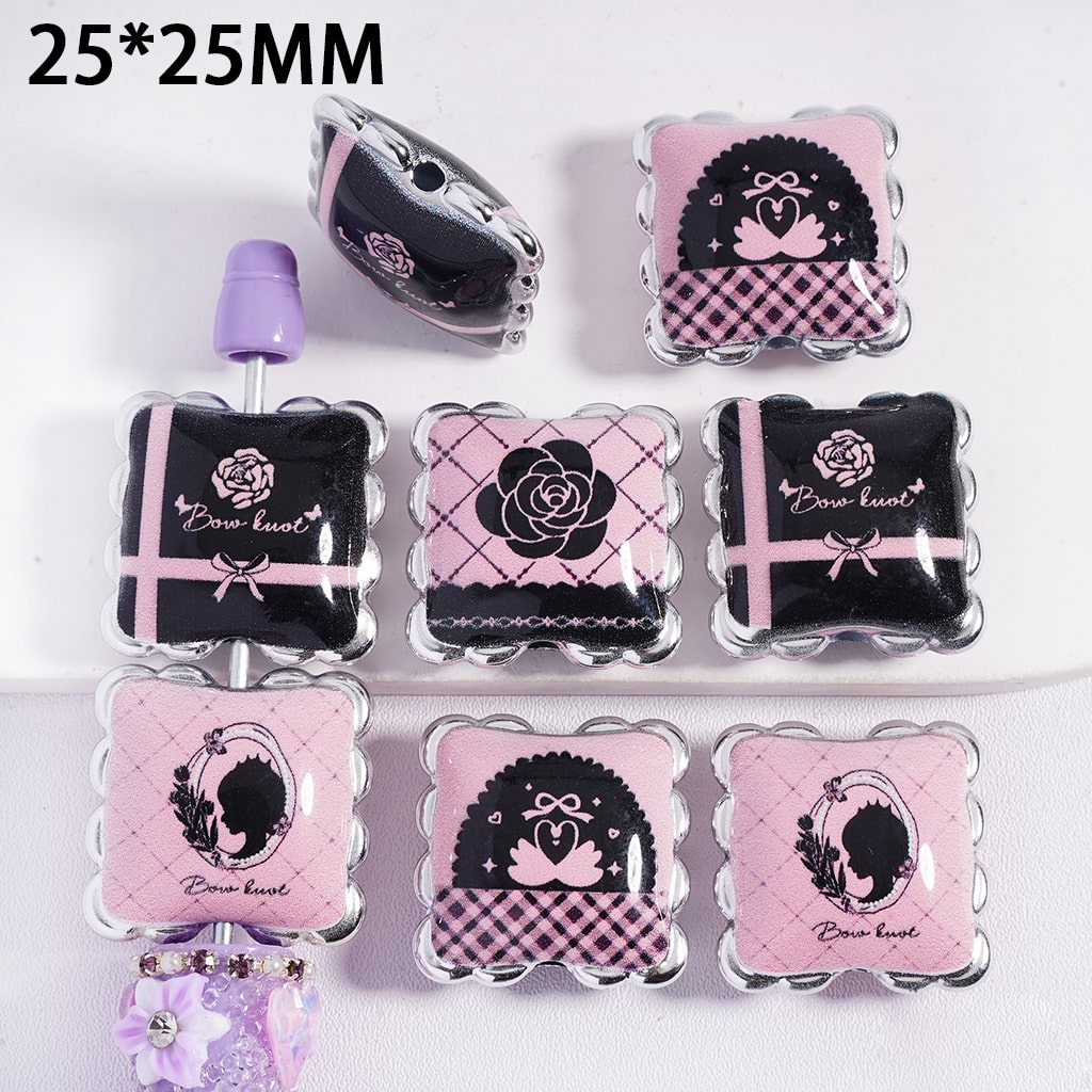 Decorative press-on nails with pink and black designs on a white background