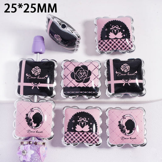 Decorative press-on nails with pink and black designs on a white background