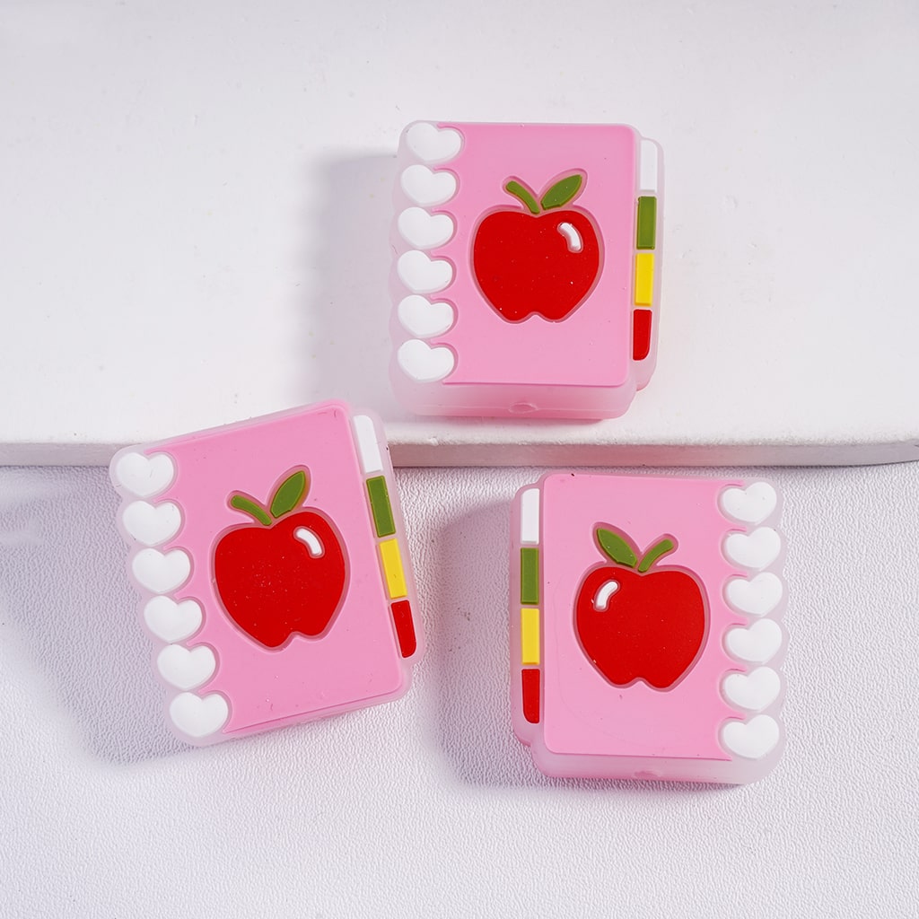 Three pink cases with red apple designs on a white background