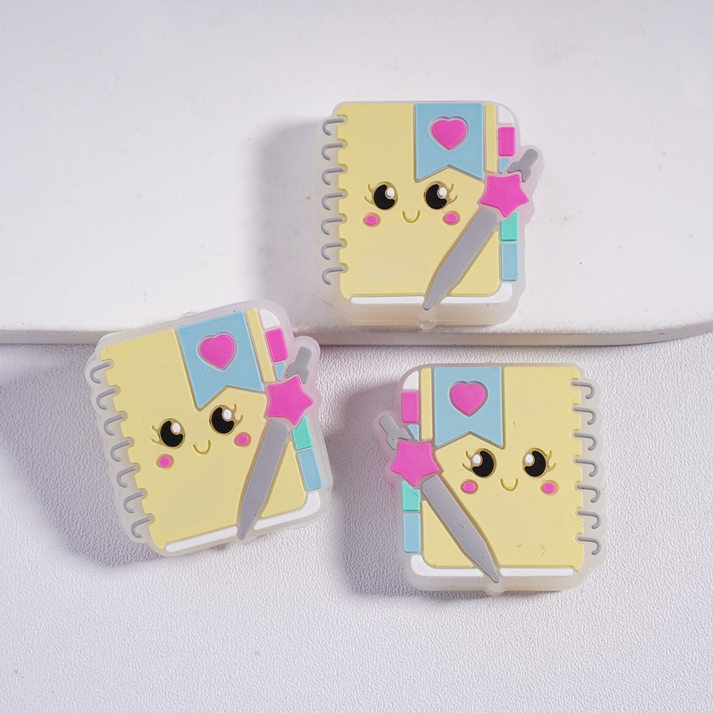 Two cartoon notebook-shaped phone cases with a happy face on a white background