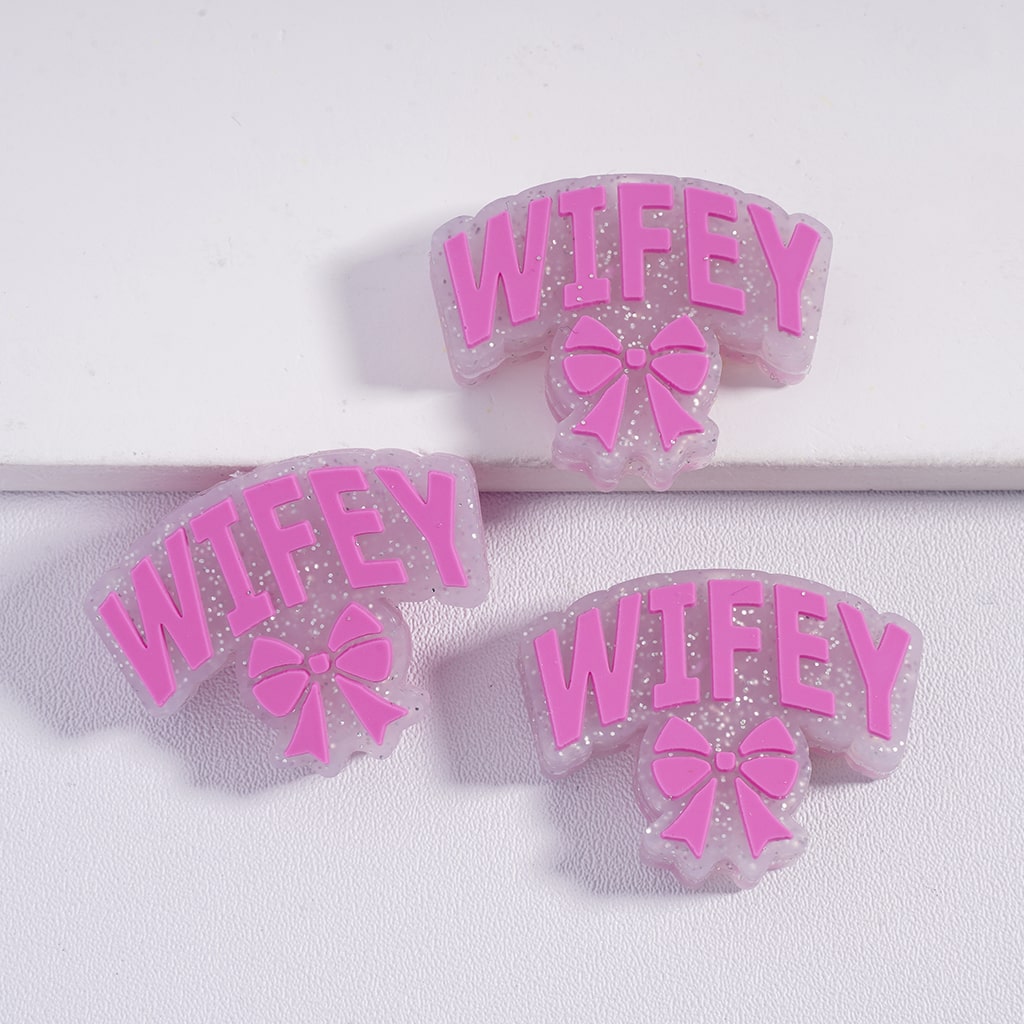 Pink 'WIFEY' hair clips with bows on a white background