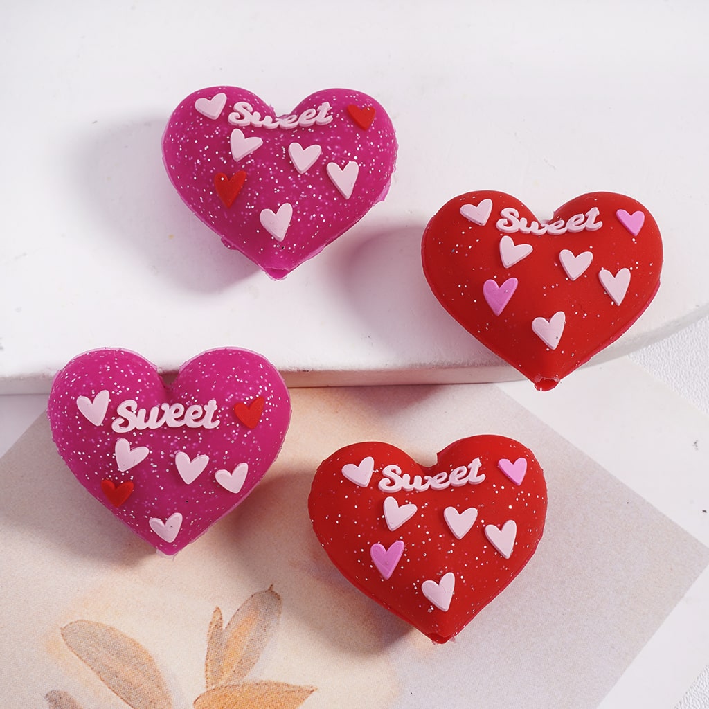 Heart-shaped cookies with 'sweet' and heart designs on a white surface.
