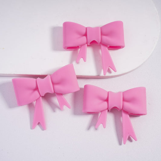 Three pink hair bows on a white background