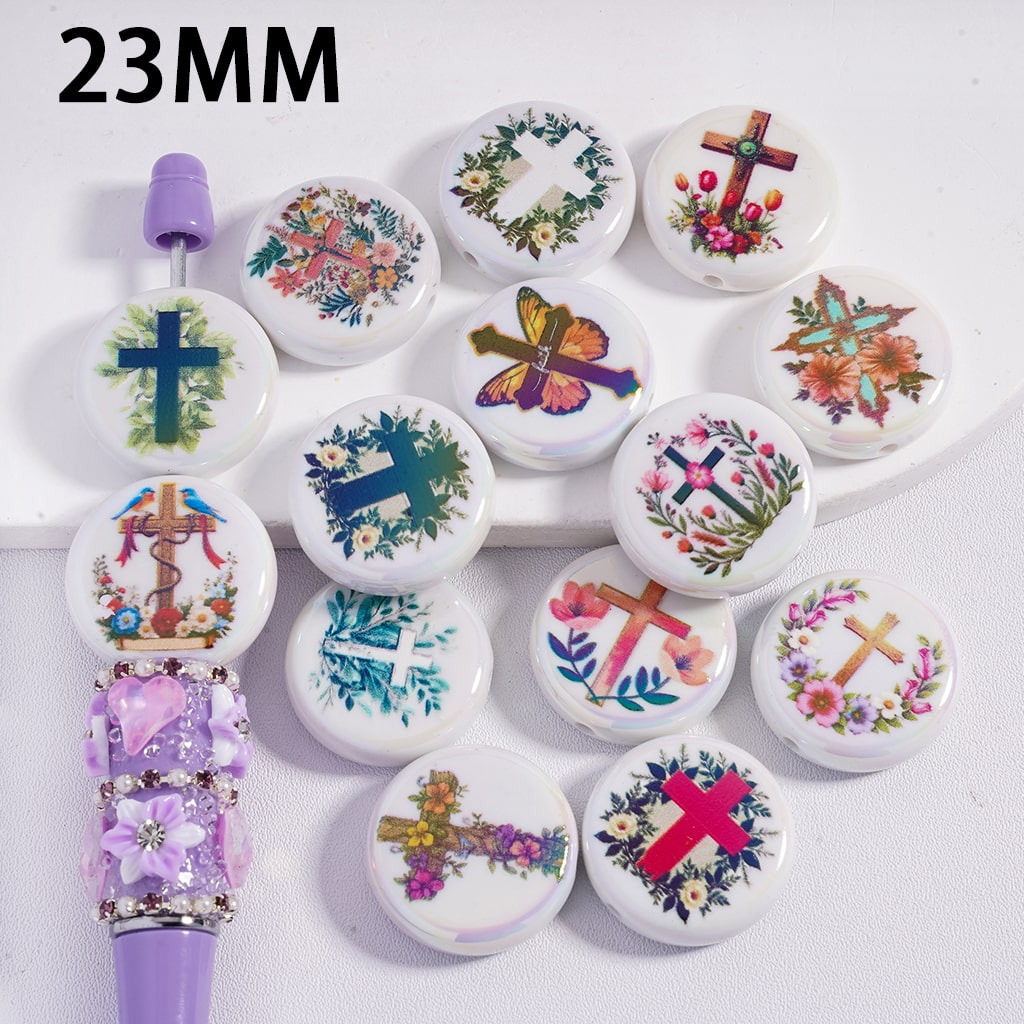 Decorative buttons with floral and cross designs on a white background, with a purple handle visible.