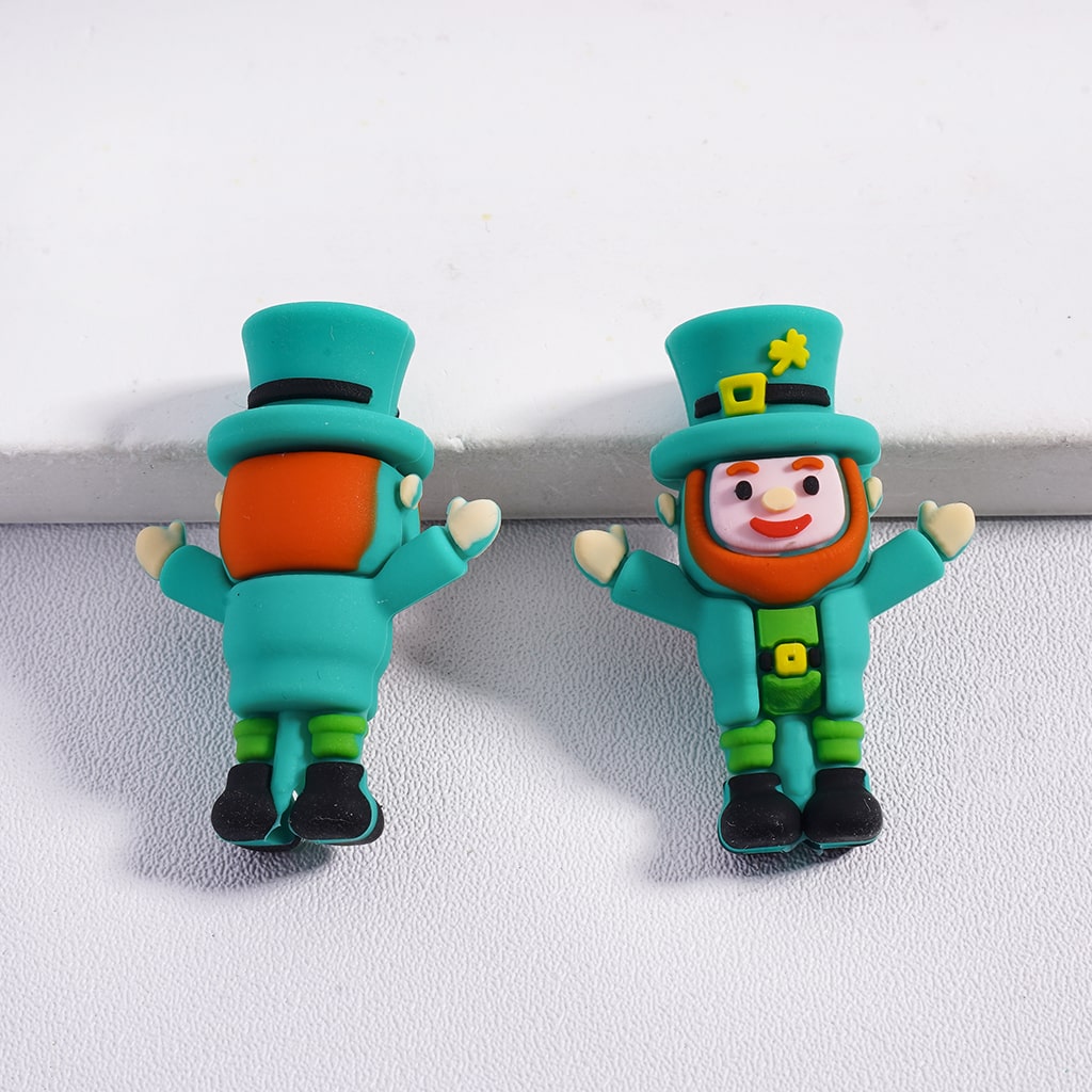 Two green leprechaun-shaped hair clips on a white background