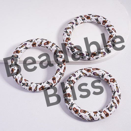 Three circular objects with a pattern of small images on a white background, branded 'beadablebliss'.