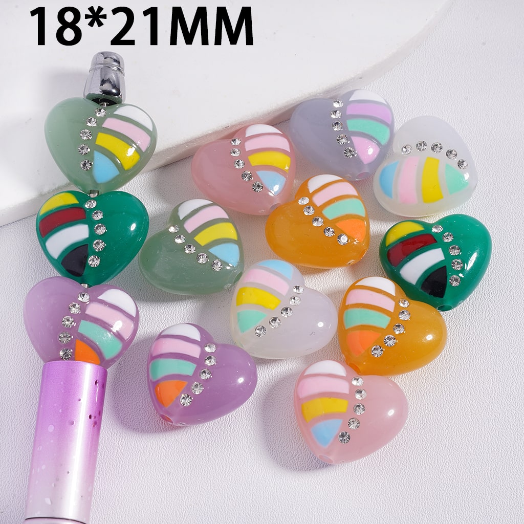 Colorful heart-shaped beads with rhinestones on a white background