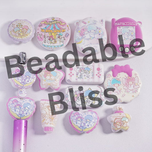 Collection of pastel-colored stationery items with cartoon designs on a white background, featuring the brand 'beadablebliss'.