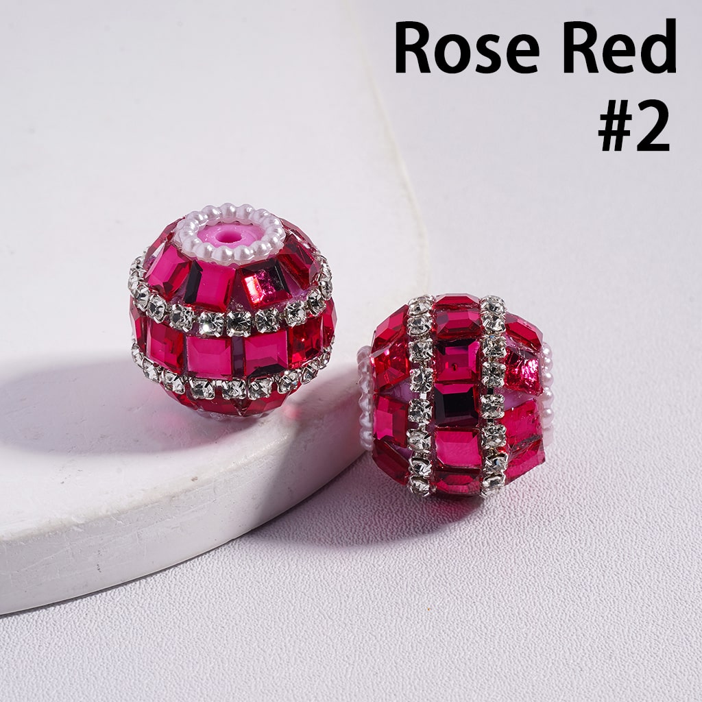 Rose red jewelry beads with silver accents on a white surface