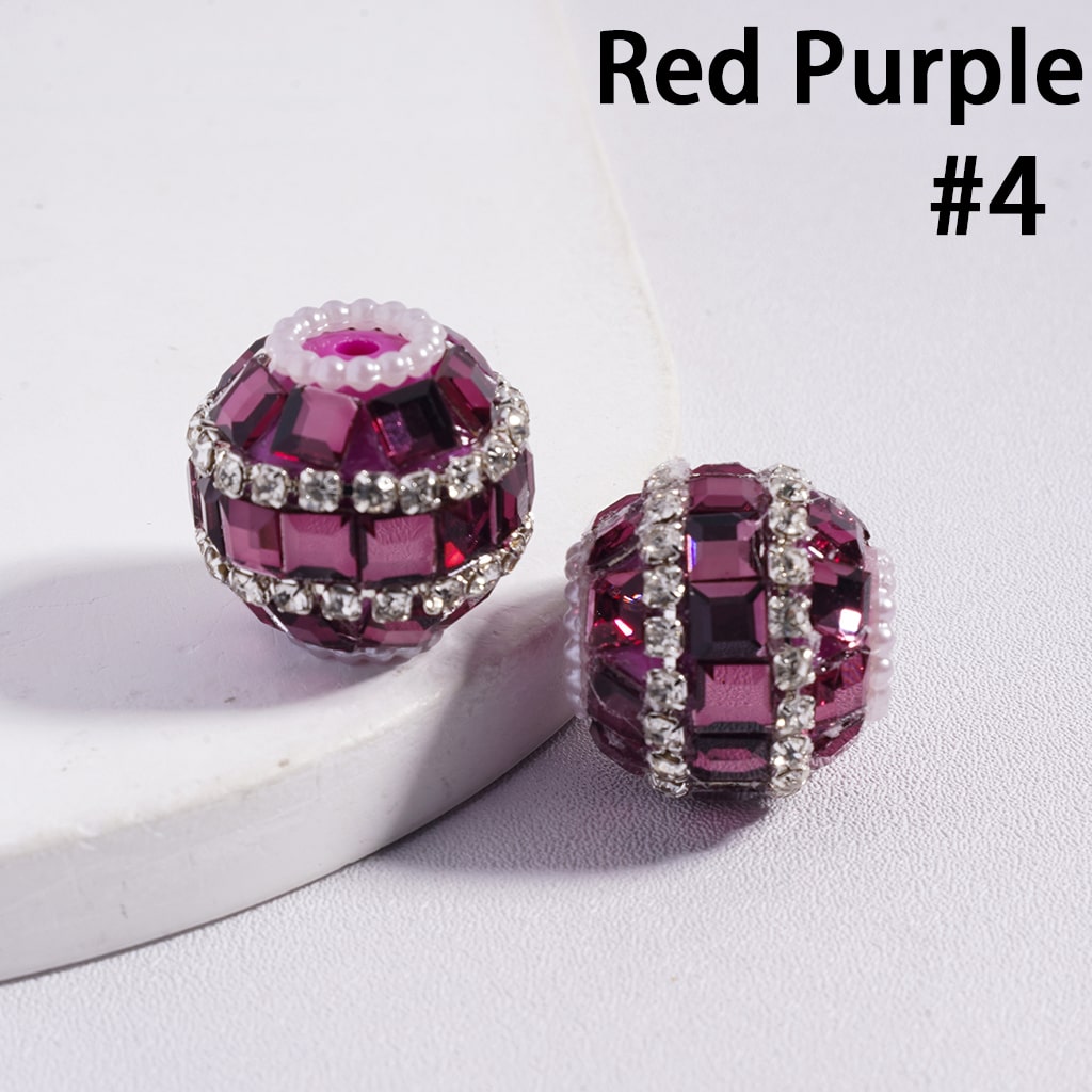 Red purple beads with silver accents on a white surface