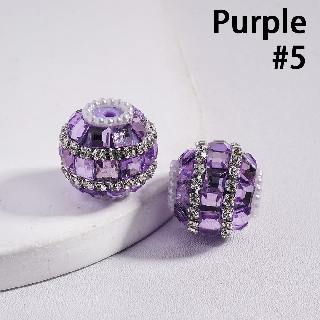 Two purple beads with silver accents on a light gray background