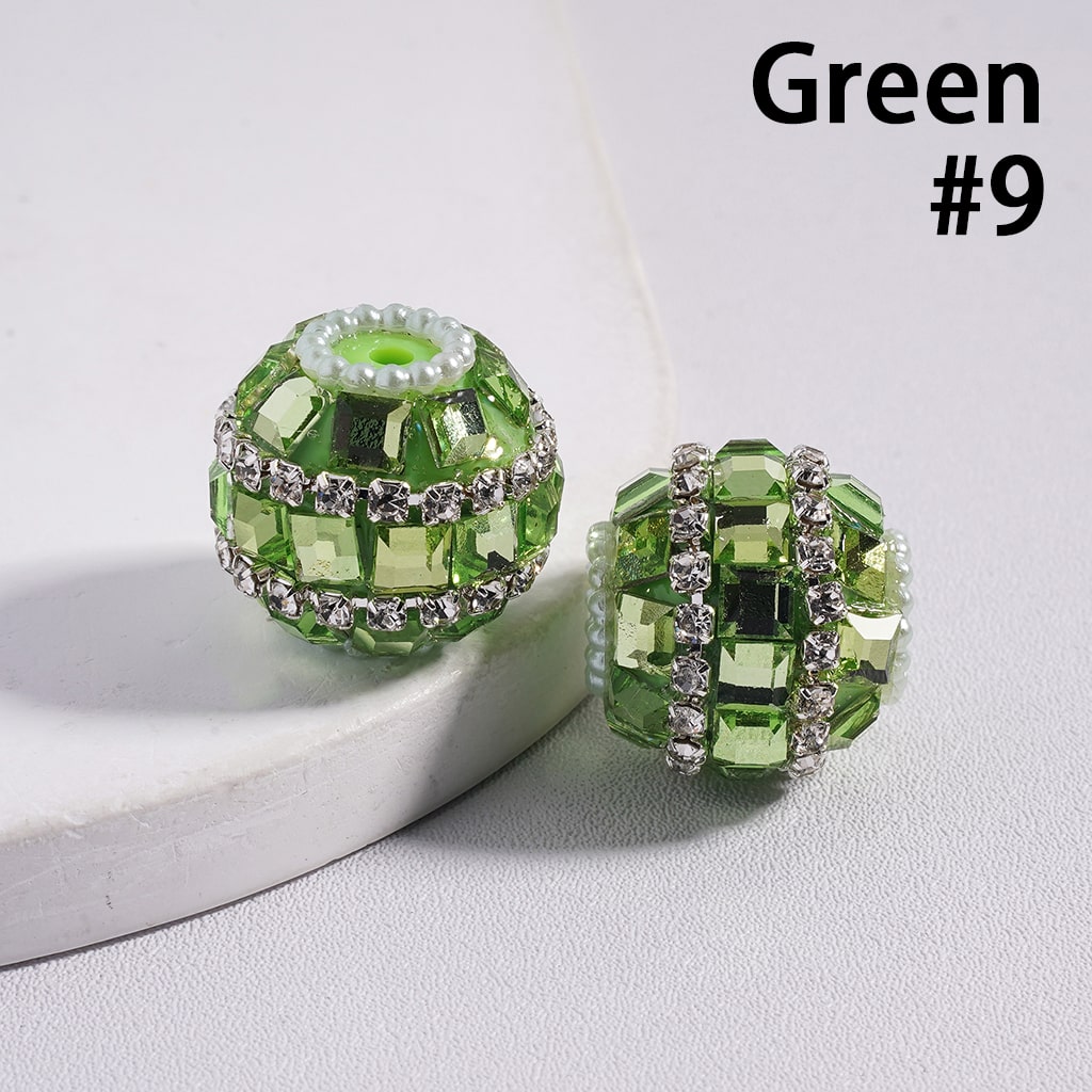Green beaded earrings with rhinestones on a white surface