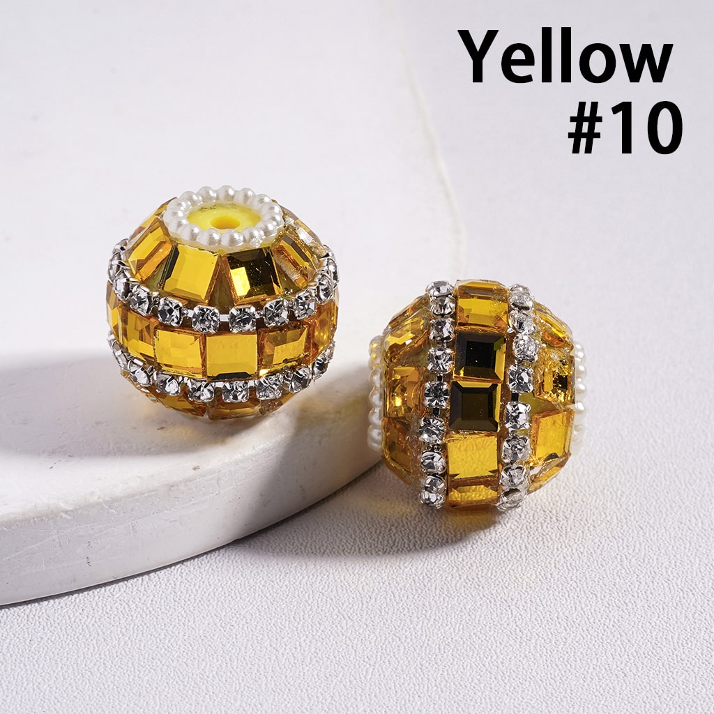 Two yellow beads with rhinestone accents on a white surface, labeled 'Yellow #10'.