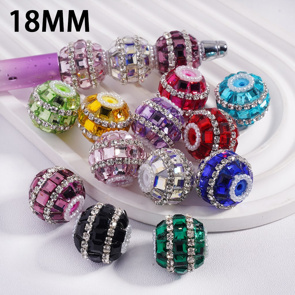 Colorful beaded charms with rhinestones on a white surface