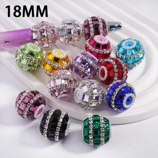 Colorful beaded charms with rhinestones on a white surface