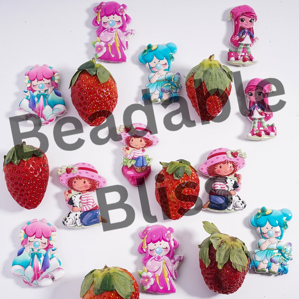Colorful figurines of girls with strawberry-shaped bodies on a white background, featuring the brand 'Beadable'.