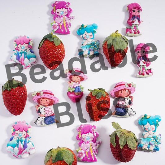 Colorful figurines of girls with strawberry-shaped bodies on a white background, featuring the brand 'Beadable'.