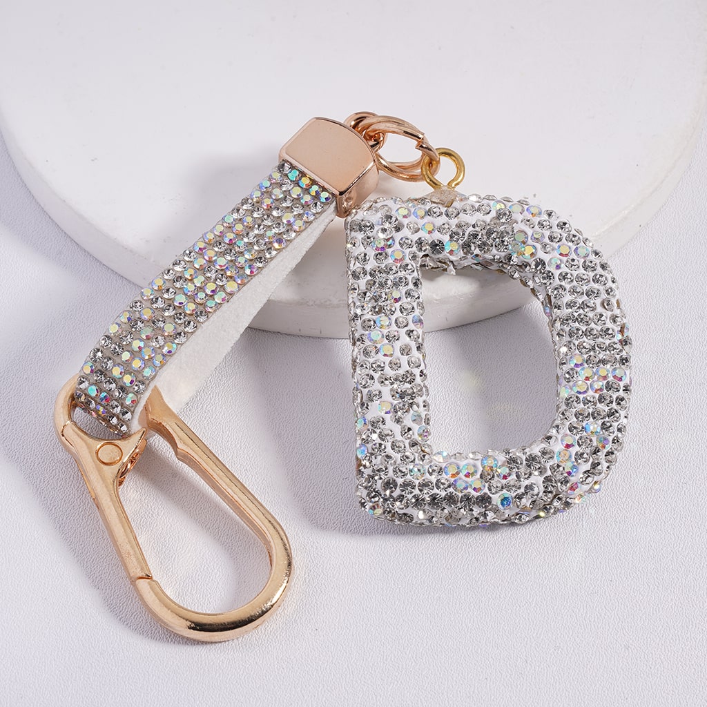 Decorative keychain with rhinestone embellishments on a light gray background