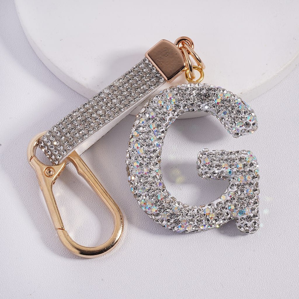 Keychain with letter 'G' made of sparkling material on a light background