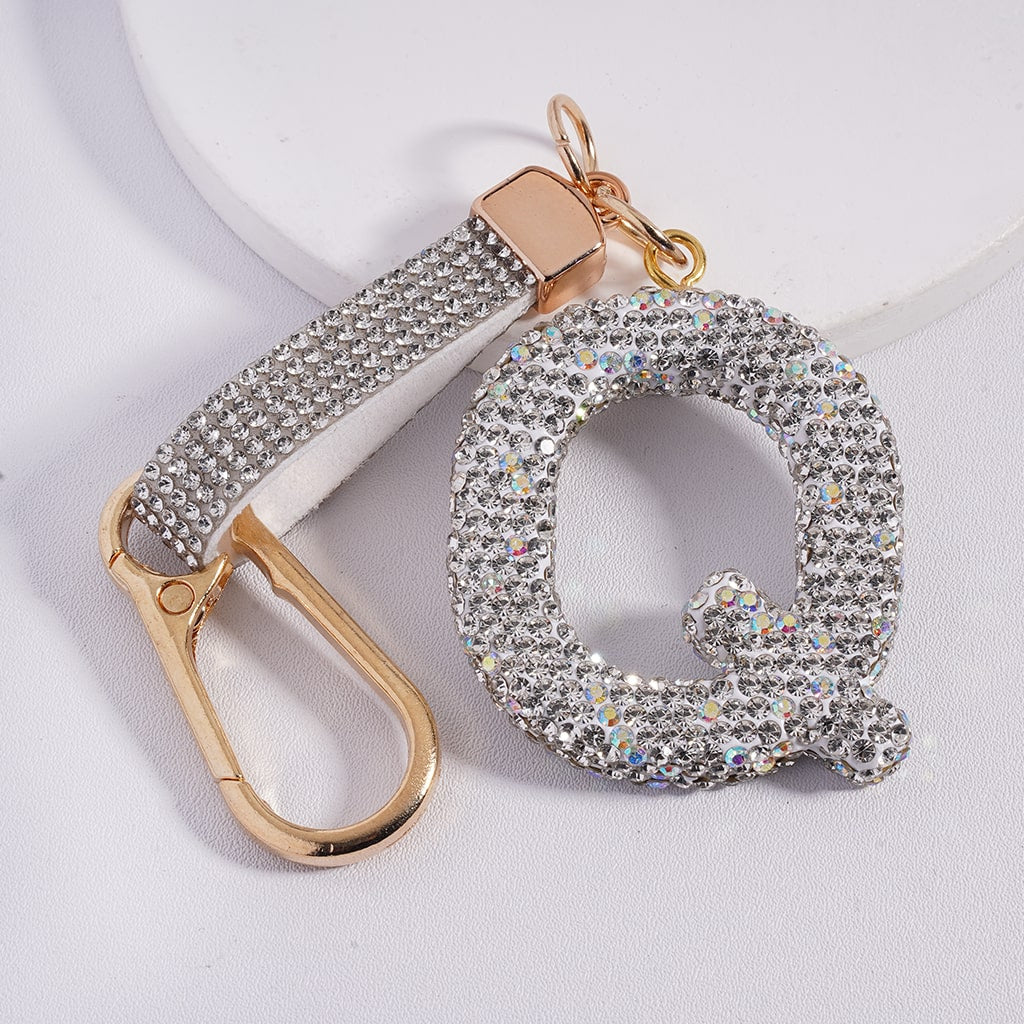 Decorative keychain with letter 'Q' and gold carabiner on a light background
