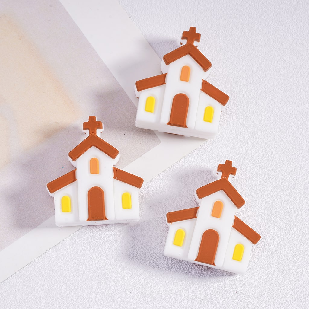 Three small models of churches on a white surface