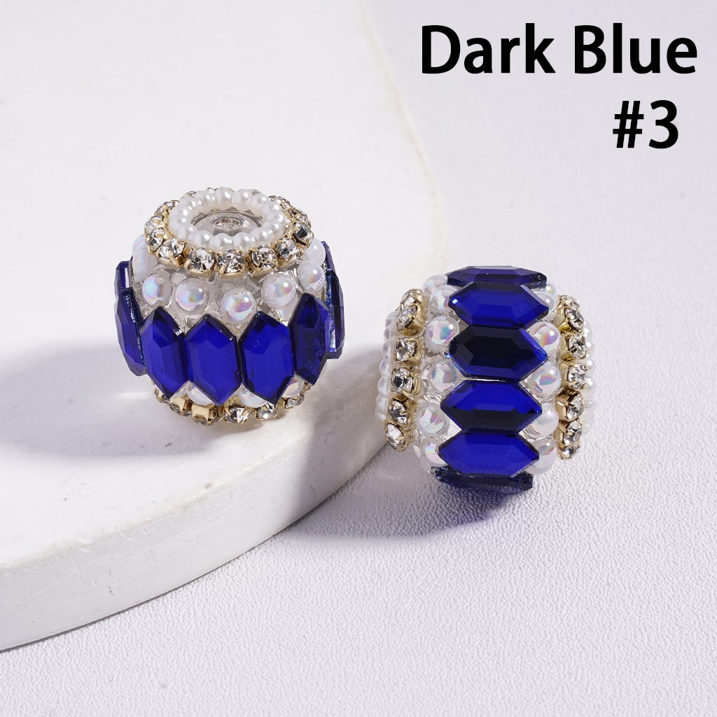 Two dark blue beaded charms with gold accents on a white background