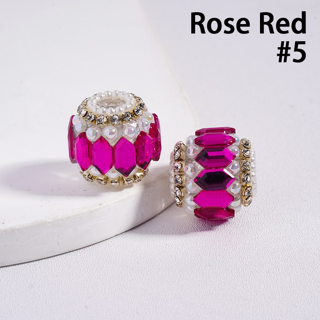 Rose red jewelry beads with gold accents on a white background