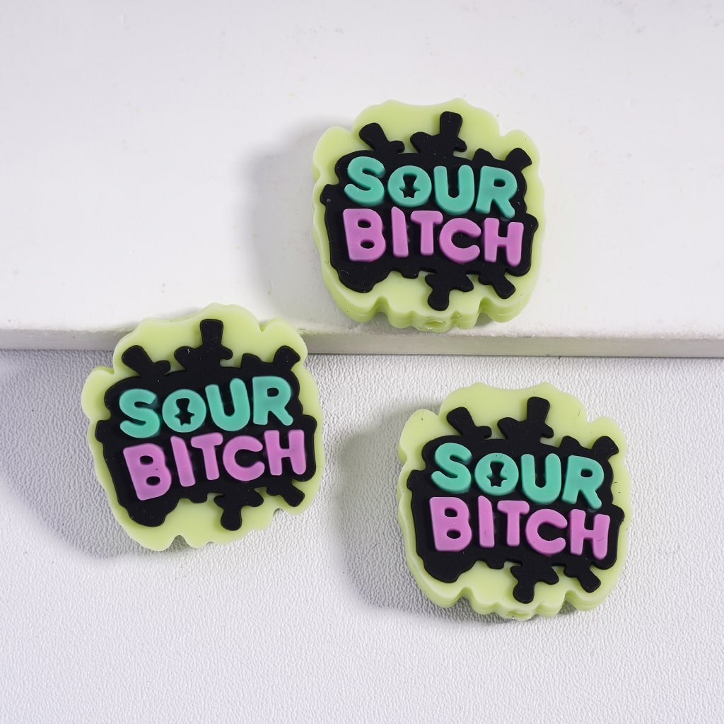 Three 'SOUR BITCH' earrings on a white background