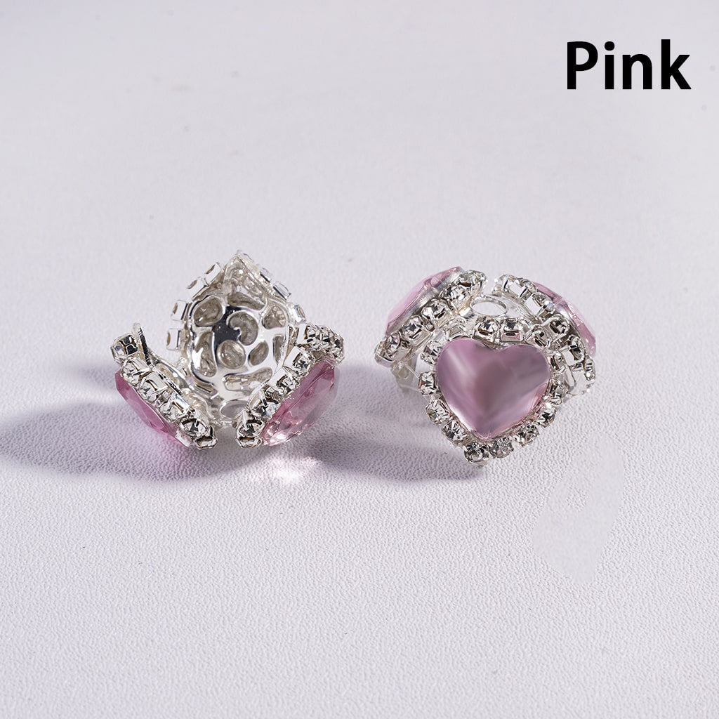 Pink heart-shaped earrings with silver accents on a light gray background