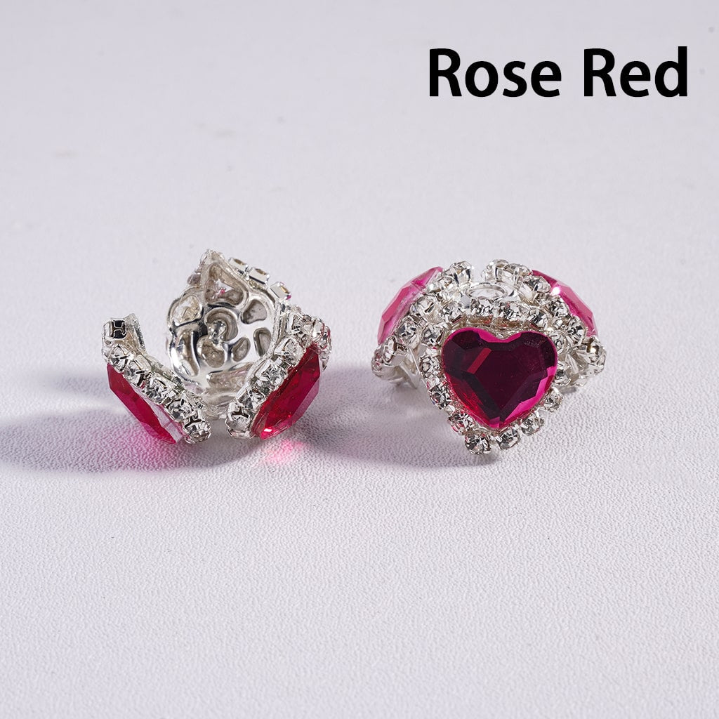 Rose red heart-shaped earrings with silver detailing on a light gray background