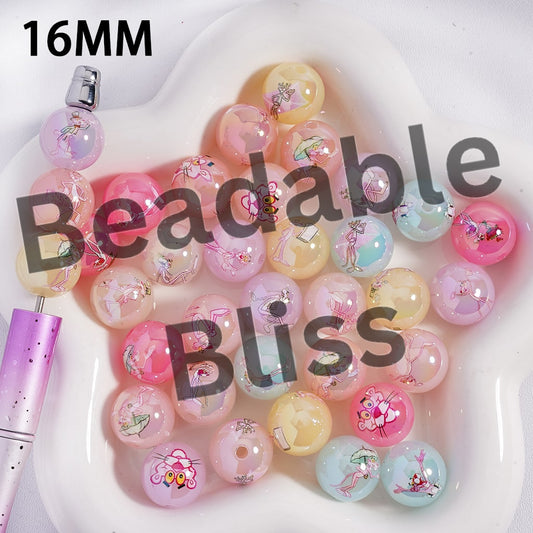 Colorful beads with decorative elements on a white surface, featuring the text '16MM Beadable Bliss'.