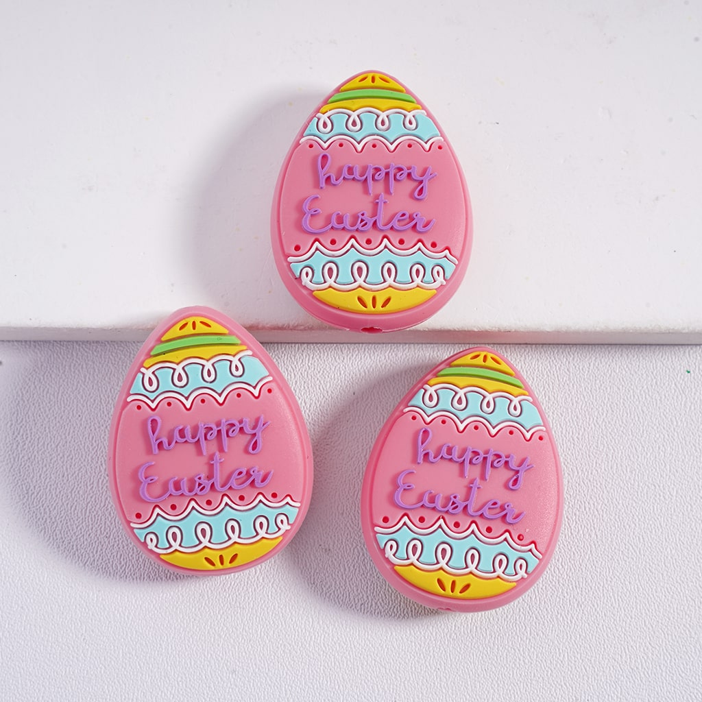 Three pink 'Happy Easter' egg-shaped cookies on a white background