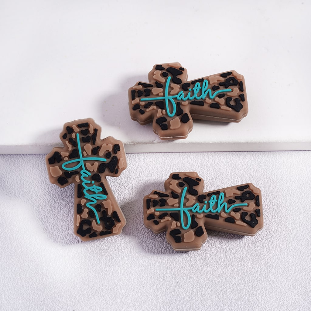 Three leopard print crosses with 'faith' written on them on a white background