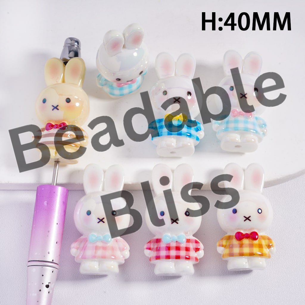 Beadable Bliss bunny-shaped beads with various outfits on a white background