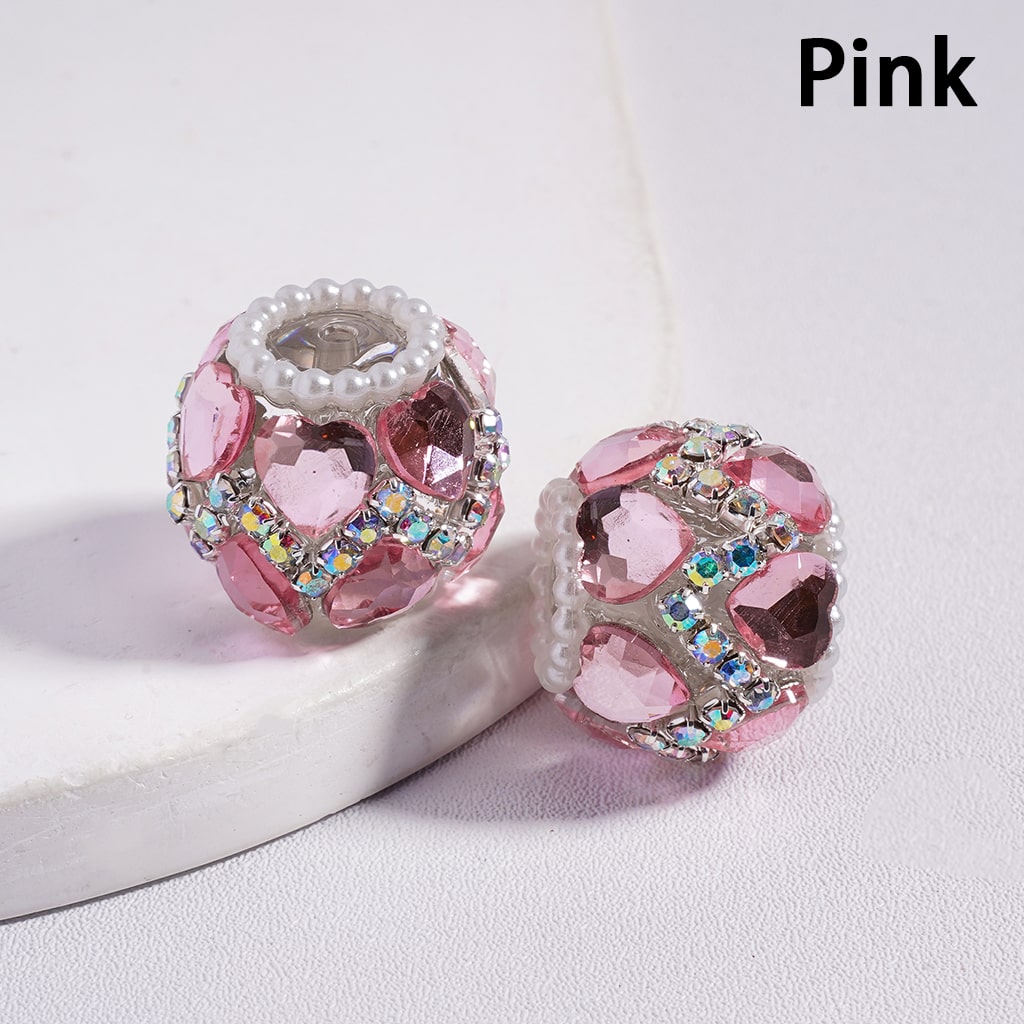 Pink beaded charm with crystal accents on a white surface