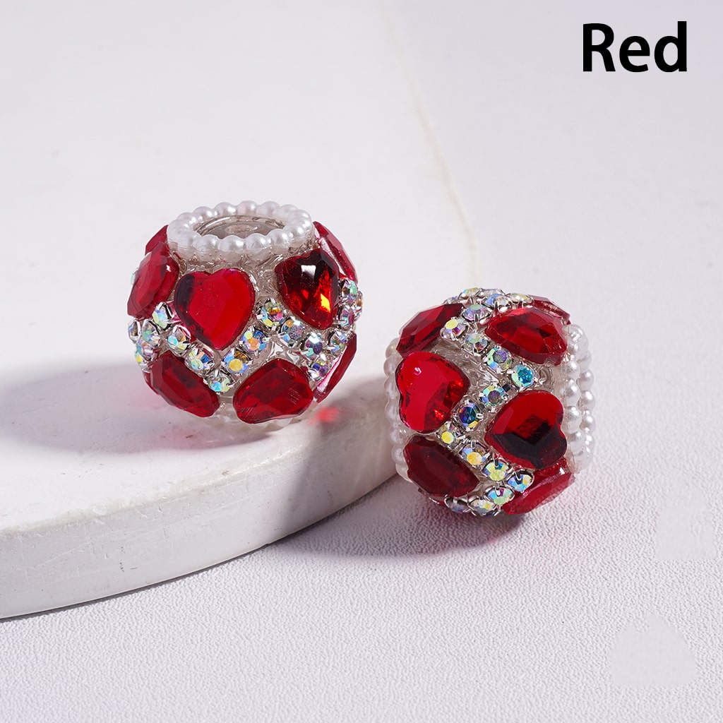 Red heart-shaped beads with clear stones on a white background