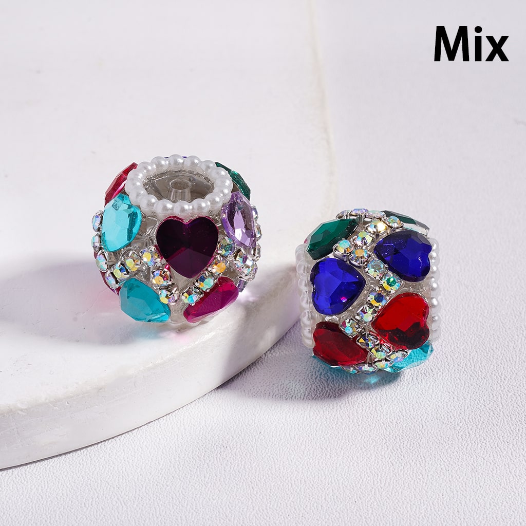 Two colorful heart-shaped beads with rhinestones on a white background