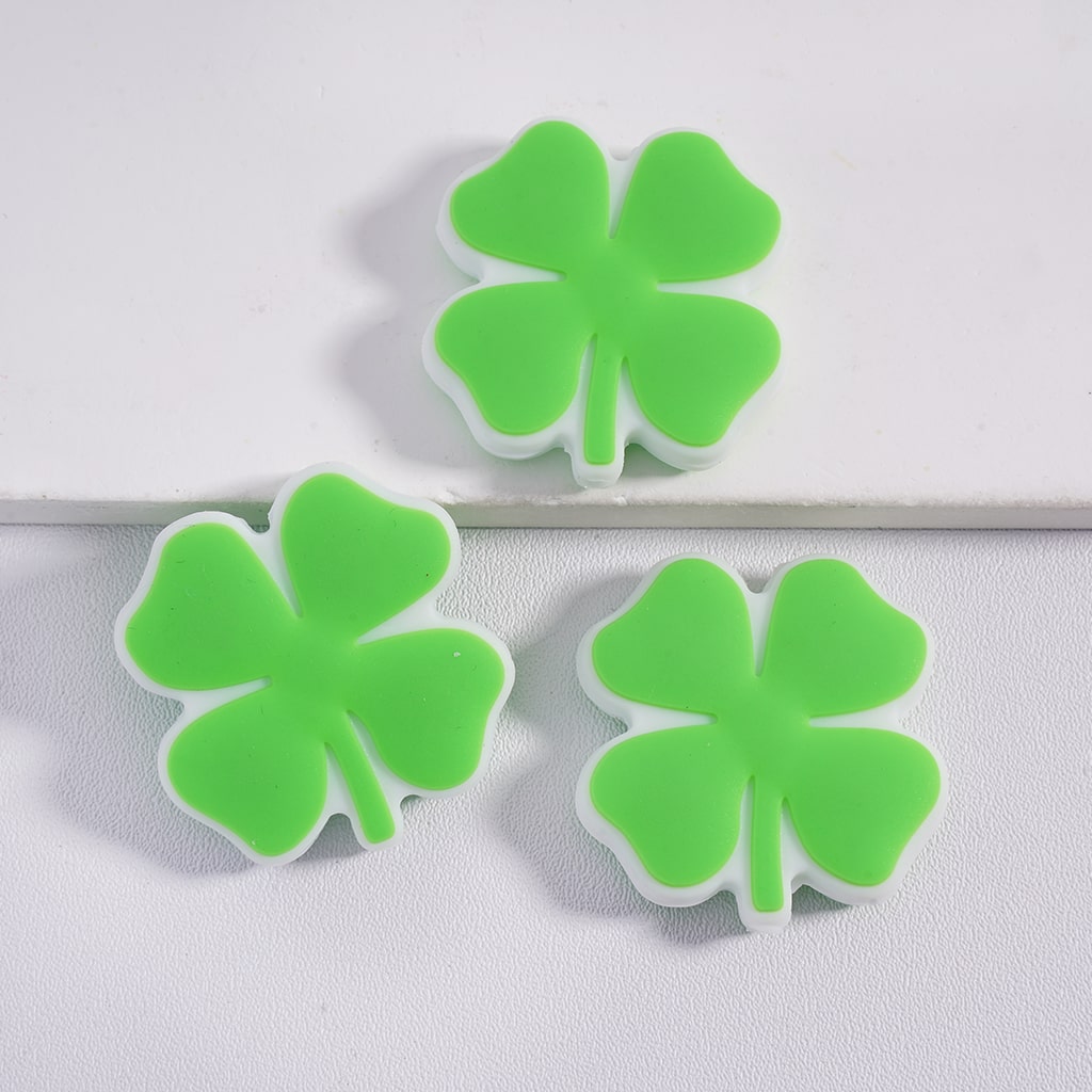 Three green four-leaf clover-shaped objects on a white background