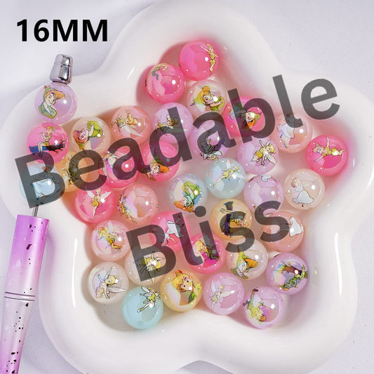 Heart-shaped dish with pink and multicolored beads featuring fairy designs, with a pink pen on a white background.