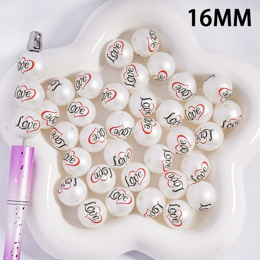 White beads with 'love' and heart designs on a white tray with a pen, labeled '16MM'.