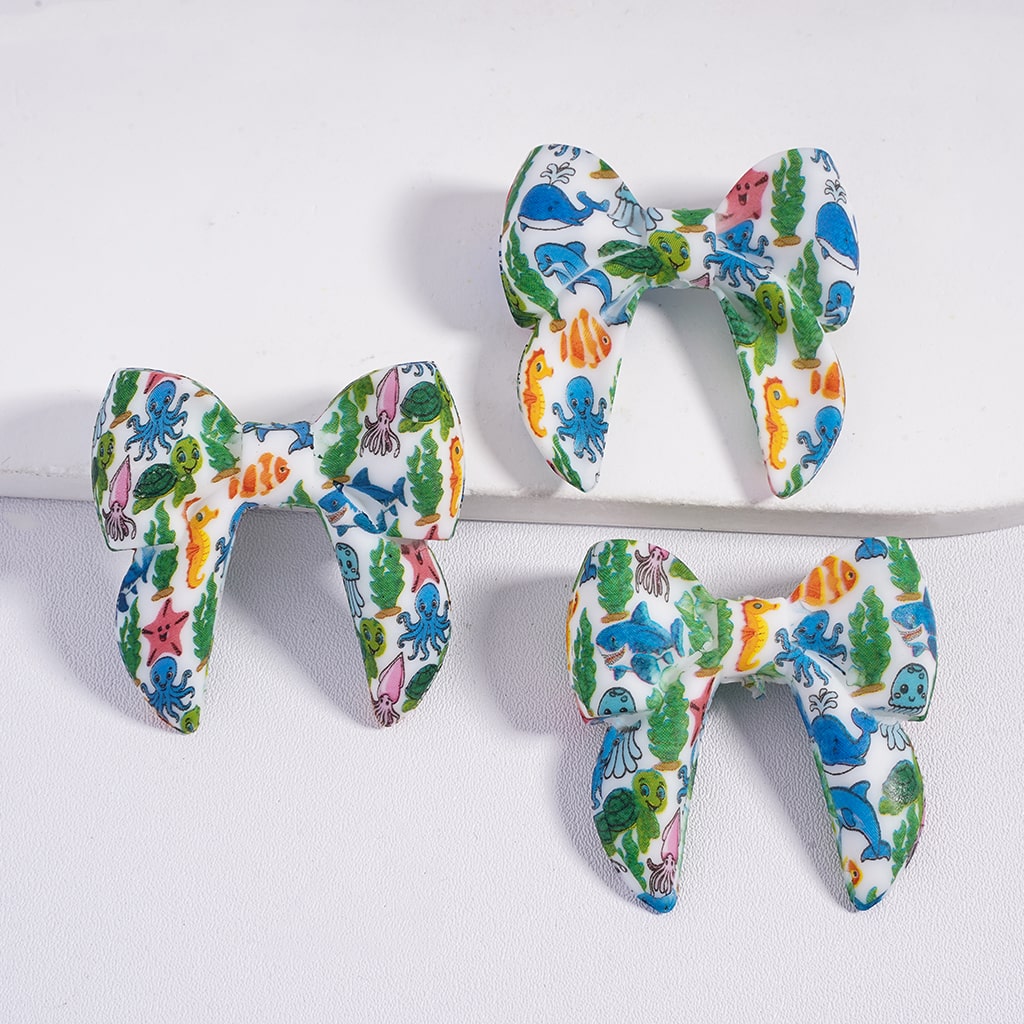 Three colorful letter-shaped toys on a white surface