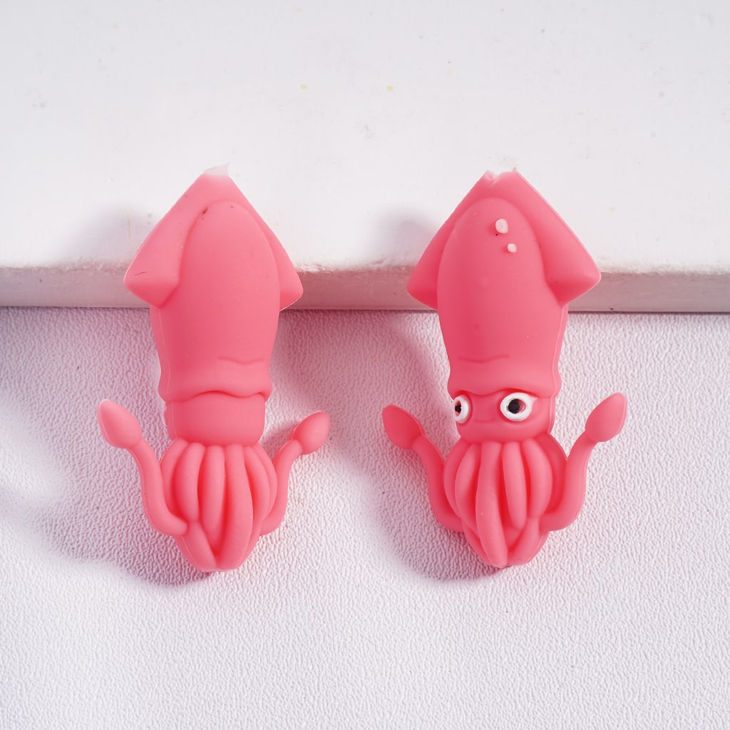 Two pink squid-shaped clips on a textured white surface