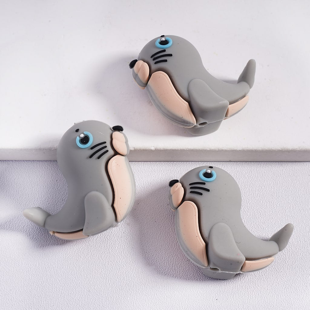 Three gray seal-shaped clips on a white background