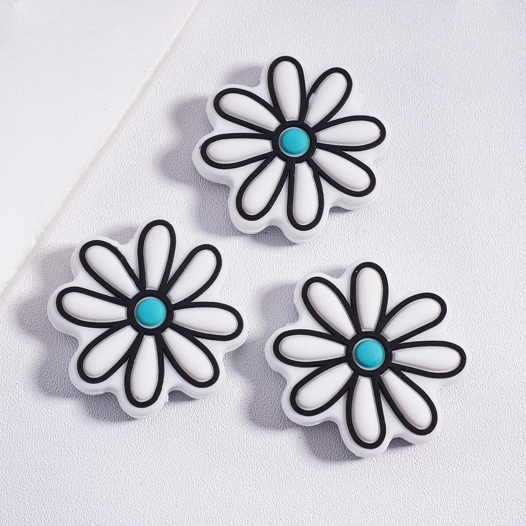 Three flower-shaped objects with black outlines and turquoise centers on a white background