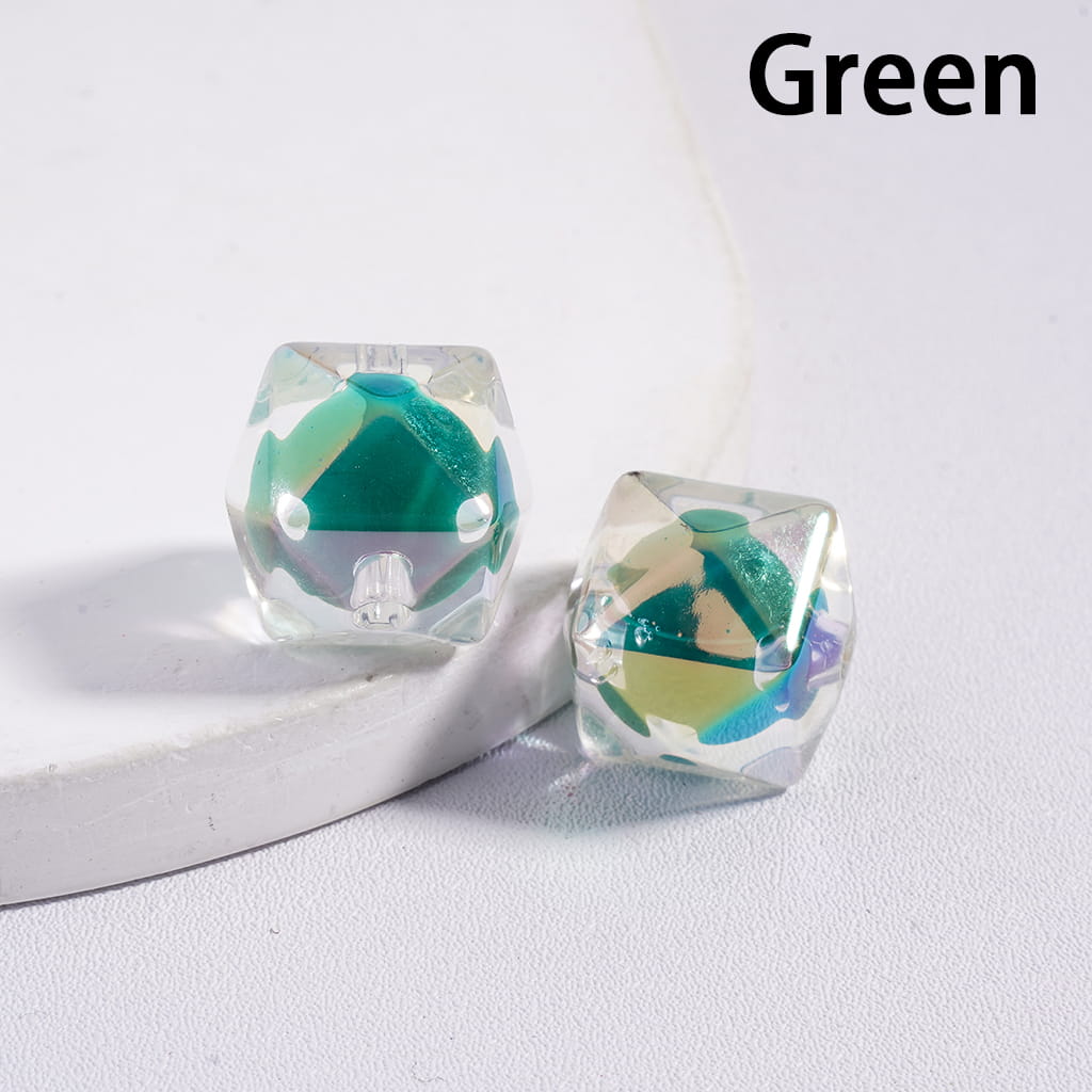 Green and clear geometric earrings on a white surface

