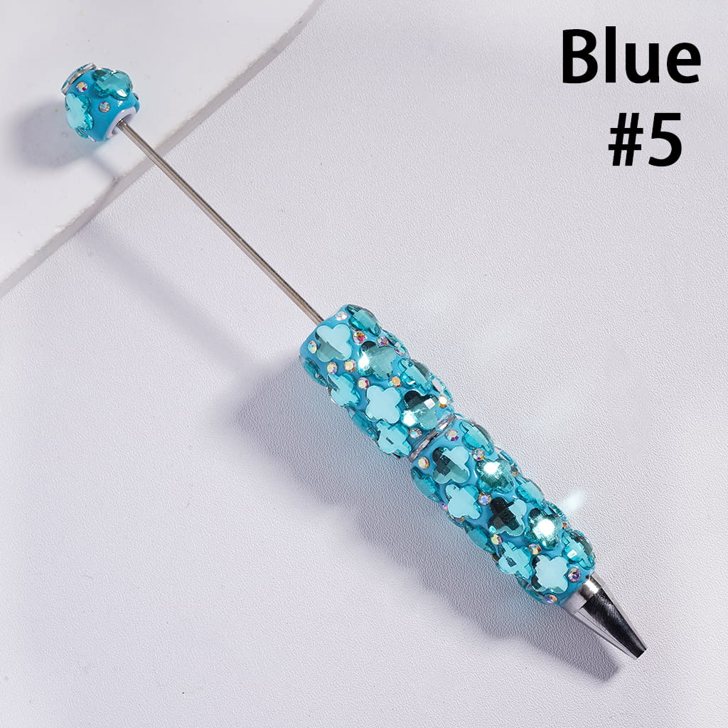 Blue decorative pen with gemstones on a light gray background