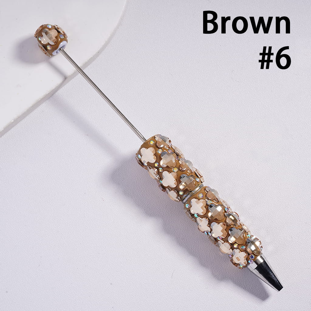 Decorative pen with brown gemstones on a white background