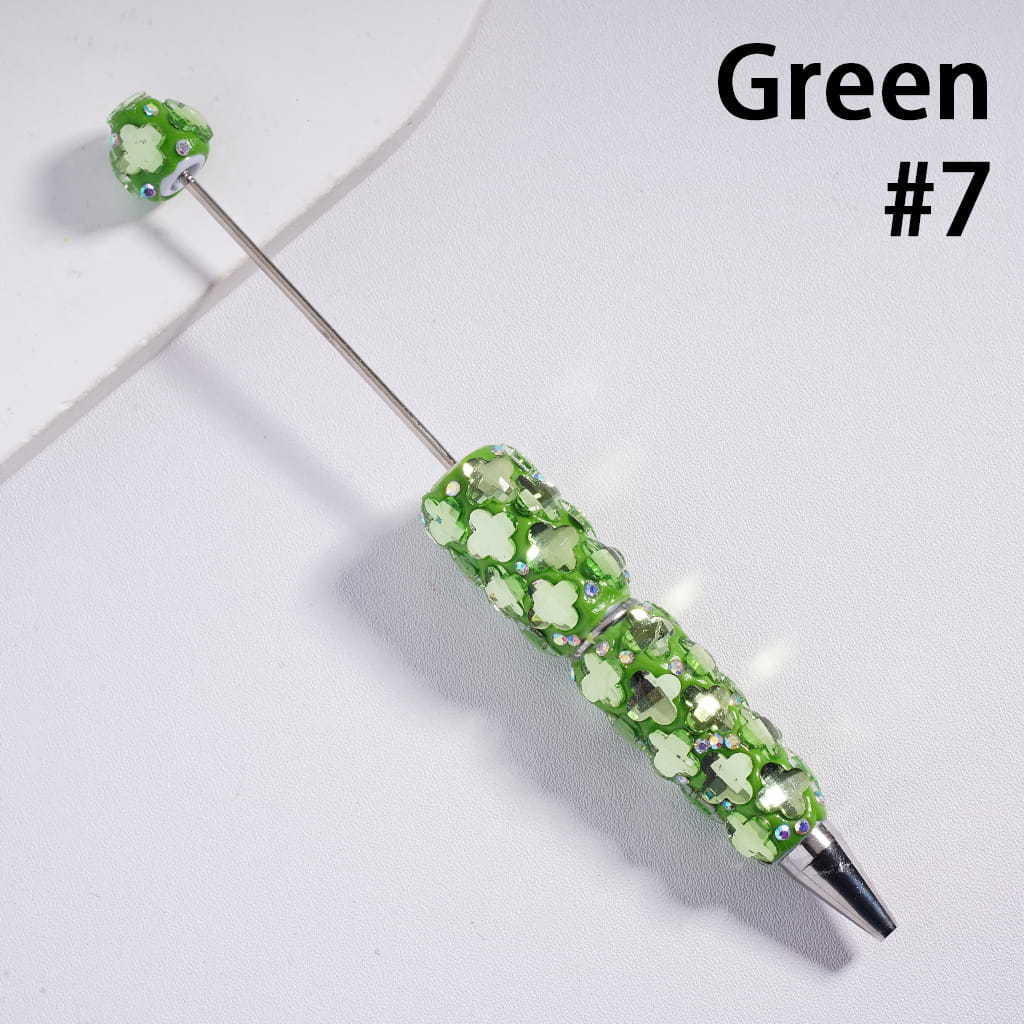 Green decorative pen with floral design on a white background